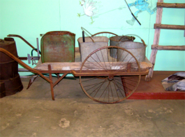Farm wheel barrow with bucket and cans c.1920 - 30s, Photograph Wollondilly Heritage Centre