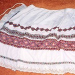 Kate: "The apron is white cotton with rows of coloured cross-stich patterns embroidered on it and a broderie Anglaise border. I think my mother [Anna] took it with her when she was deported by the Germans from the Ukraine and sent to work in Austria."