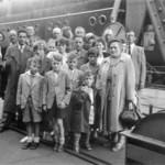 "I have a group photo of the family taken before we went aboard and my little brother Peter can be seen holding my little doll that I brought with me and still have."