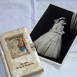 "The small prayer book has a pearlised cover with an image of Jesus on the front. I am aged 10 in the photo in First Communion dress. I brought these items to Australia because my faith is important to me."