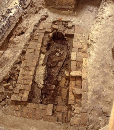 Of the four graves discovered, only one was relatively intact. This grave is shown in the photograph. Excavation revealed a brick vault enclosing the remains of a wooden coffin set in clay. The coffin was made of Australian red cedar, and fastened with iron nails and brass tacks. Forensic examination of the skeletal remains revealed that the bone fragments belonged to a woman. Following the excavation, the remains were re-interred during a simple ceremony conducted by the Anglican Dean of Sydney. The grave was filled in with sand and the bricks rebuilt across the top of the vault. Courtesy City of Sydney Archives.