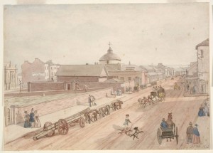 Hand-coloured photographic print after a John Rae watercolour, showing a view north along George Street, c.1840s. The Old Sydney Burial Ground cam be seen to the left of the picture, enclosed by a tall brick wall. A range of memorials are depicted: altar tombs, ledger stones and headstones. Courtesy State Library of New South Wales