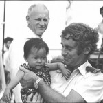 Customs Officer Frank Dalton holding a Vietnamese refugee child, Xye Than Hue on the deck of the Tu Do in Darwin, November 1977. Courtesy National Library of Australia