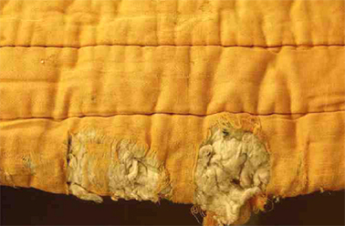 Detail of wool stuffing, seen at the most worn part of the quilt.