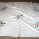 "I brought with me this sugar bag tablecloth I made and embroidered during the war in the 1940s. Sugar in those days came in cotton bags so when one was empty I must have asked for it."