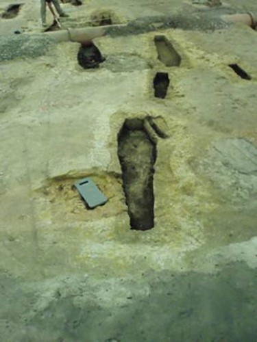 There are a number of smaller grave cuts, indicating the graves of infants. This photograph shows the excavation of a grave of an adult and infant buried together. Bone fragments have confirmed this was the grave of a woman; she probably died during childbirth. Courtesy City of Sydney Archives.