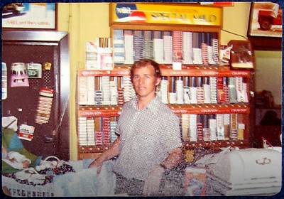 Marius de Vos with baby son Dean, managing Geoffrey’s Newsagency, Argyle Place, The Rocks, Sydney, Australia, 1971.