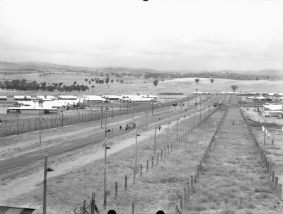 A general view of the access road separating the four compounds of the Cowra Camp. B and C compounds are on the left while A and D compounds are on the right. Courtesy Australian War Memorial